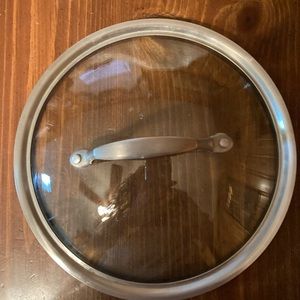 Glass and metal lid with thick metal handle 9 inches wide Heavy also